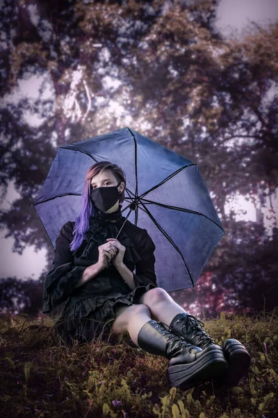 Mulher Vestido Preto Uma Máscara Sentada Grama Noite Com Guarda — Fotografia de Stock