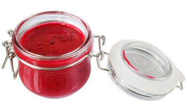 Beyaz arka planda izole edilmiş açık cam bir kavanozda kirazlı krema balı..