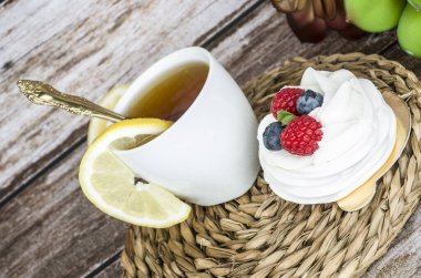 Ahşap bir arka planda çilekli çay ve pasta..