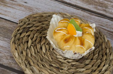 Tahta arka planda kremalı ve meyveli kek..