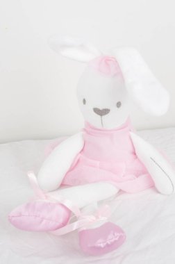 Beyaz arka planı olan pembe elbiseli sevimli bir tavşan. 