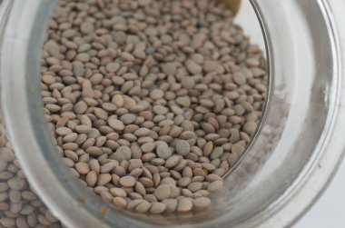 Beyaz arkaplanda kahverengi mercimek