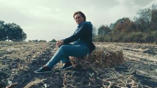 一个成熟的女人在干草堆上女农民在大片大片的土地上栖身 — 图库视频影像
