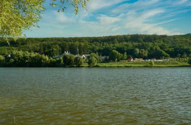 Göl manzarası ve gölün yakınındaki büyük ormanda eski bir manastır. Thiganesty Manastırı, Moldova Cumhuriyeti.