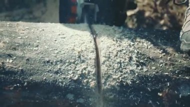 Tahta kütüğü testere ile kesiliyor.