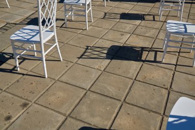 Sosyal uzaklık için hazırlanmış geniş bir grup boş beyaz sandalye açık hava iş konferansına konuk ağırlamaya hazır. COVID-19 salgın sırasında sağlık ve güvenlik tedbirleri insanlar arasında mesafe gerektirir