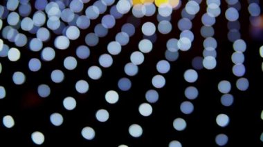 Siyah arka planda çok renkli bokeh ışıkları parıldıyor. Yeni yıl arkaplanı. Soyut bulanık Noel şenlik videosu.