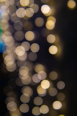 Yılbaşı çelenklerinin arka planı yıldızlar gibi. Noel atmosferinde çelenkler yankılanıyor.