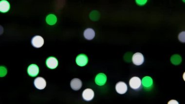 Siyah arka planda çok renkli bokeh ışıkları parıldıyor. Yeni yıl arkaplanı. Soyut bulanık Noel şenlik videosu.