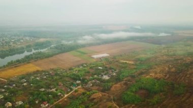 Yavaşça bir nehir kıyısına bakıyorum Dinyester ve sabah güneşiyle kaplı küçük bir köy..