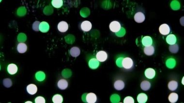 Siyah arka planda çok renkli bokeh ışıkları parıldıyor. Yeni yıl arkaplanı. Soyut bulanık Noel şenlik videosu.