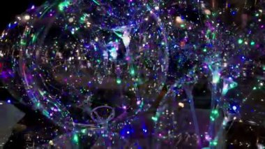 Siyah arka planda çok renkli bokeh ışıkları parıldıyor. Yeni yıl arkaplanı. Soyut bulanık Noel şenlik videosu.