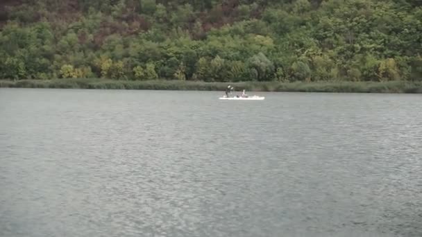 カヤックの観光客は葦の間の川に沿って泳ぐ — ストック動画