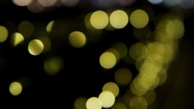 Siyah arka planda çok renkli bokeh ışıkları parıldıyor. Yeni yıl arkaplanı. Soyut bulanık Noel şenlik videosu.