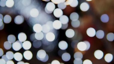 Siyah arka planda çok renkli bokeh ışıkları parıldıyor. Yeni yıl arkaplanı. Soyut bulanık Noel şenlik videosu.