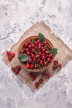 Gri arka planda kırmızı kirazlı kase, üst görünüm