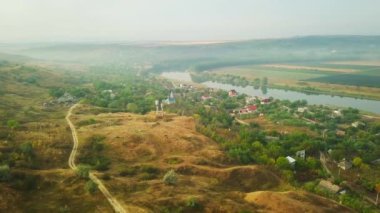 Yavaşça bir nehir kıyısına bakıyorum Dinyester ve sabah güneşiyle kaplı küçük bir köy..