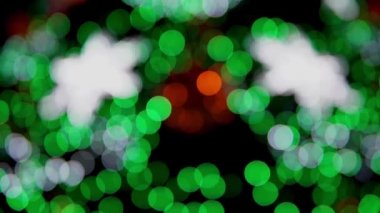 Siyah arka planda çok renkli bokeh ışıkları parıldıyor. Yeni yıl arkaplanı. Soyut bulanık Noel şenlik videosu.