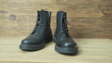 Kaliteli ahşap arka plandaki erkekler için pahalı deri çizmeler.