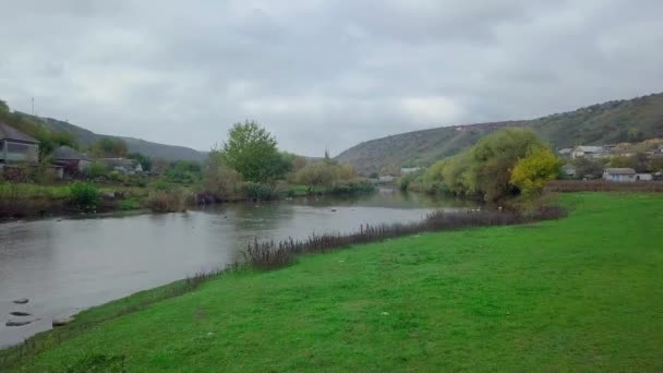 秋の風景の中に川や小さなモルダヴィアの村の上にドローン便 モルドバ共和国 — ストック動画