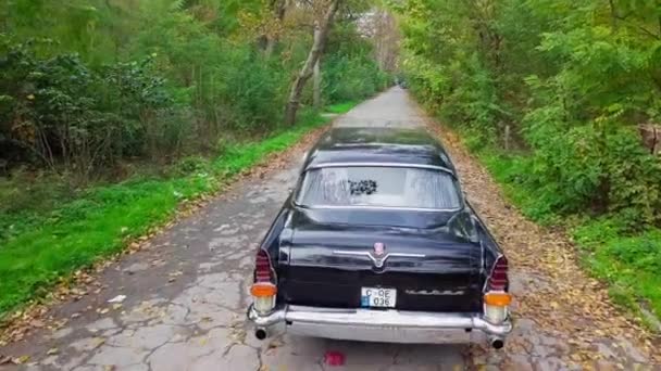 Moldavská republika, Kišiněv, 5. listopadu 2020: Sovětský retro vůz GAZ-13 Racek v podzimním parku. Horní pohled. — Stock video