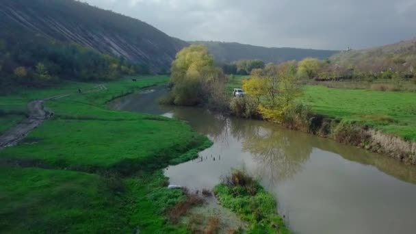 秋の風景の中に川や小さなモルダヴィアの村の上にドローン便。モルドバ共和国. — ストック動画