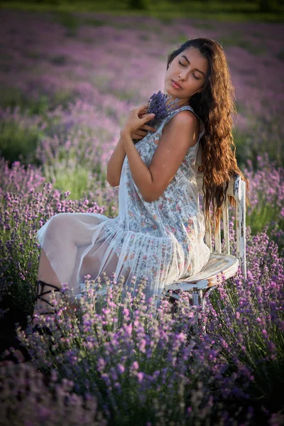 Aranyos barna lány portréja a levendula mezőn. Nyári levendula modell pózol a kamera előtt. — Stock Fotó