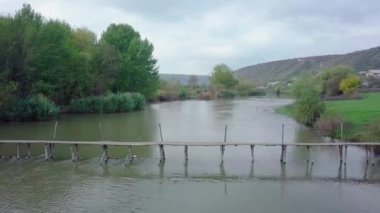 Nehrin üzerinden uçmak ve sonbaharda küçük tahta bir köprü. Raiut Nehri, Moldova Cumhuriyeti.
