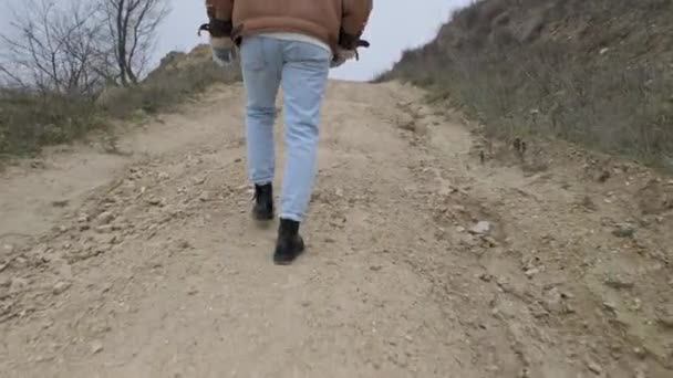 Egy Fiatal Fickó Dzsekiben Farmerben Sétál Egy Elhagyatott Kőhordó Mellett — Stock videók