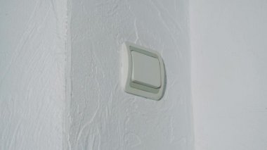 Bir adamın eli ışık düğmesini kapatır ve karanlık olur. Kapat..