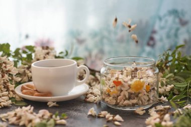 Bir fincan kahve ve akasya yakın plan. Beslenmek. Arka planda bir fincan kahve ve akasya çiçekleri.