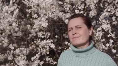 Bahçedeki bahar ağacının ortasında çiçek açan güzel genç bir dişi.