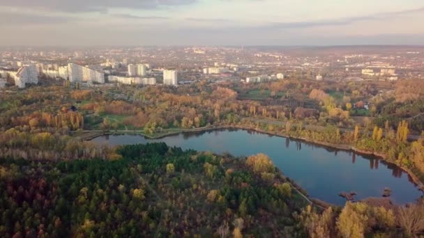 Luftaufnahme mit Drohne über einer Stadt, Haus mitten im Park. Schön geschützter See. Die Stadt Chisinau von oben gesehen. Schöne Herbstlandschaft. — Stockvideo
