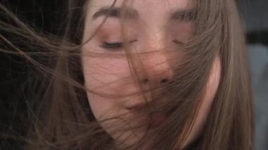 Rüzgarda dikilen kızın portresi. Breeze kızların saçlarıyla oynuyor..