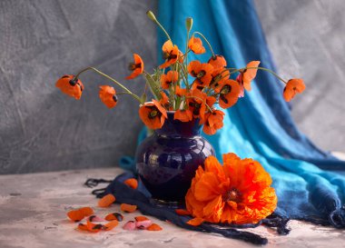 Mavi seramik vazoda kırmızı haşhaş buketi