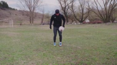 Futbolcu vücudunu ve kaslarını formda tutuyor, stadyumda sıkı çalışıyor, spor yapıyor.