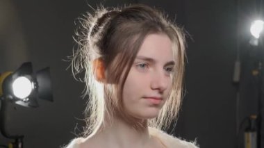Stüdyoda sakince kameraya bakan kahverengi saçlı genç kızın portresini kapat..