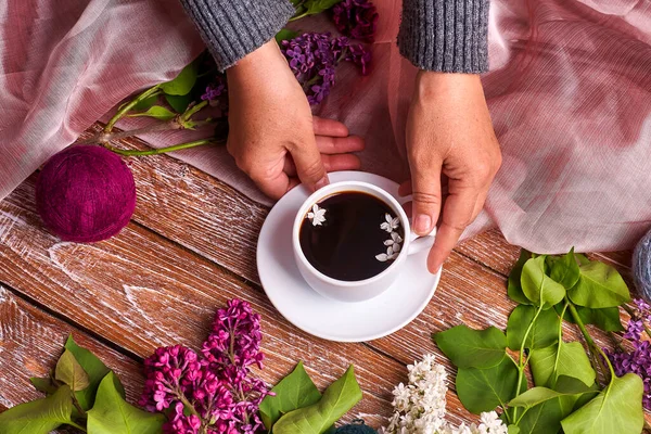 上から見ると 春のライラックの花の枝が木の背景に咲く朝のコーヒーカップを手に持っています フラット地下スタイルを置く 高価な色だ 花の創造的なデザイン — ストック写真