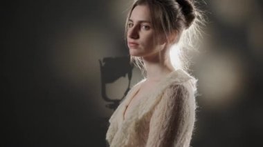 Stüdyoda sakince kameraya bakan kahverengi saçlı genç kızın portresini kapat..