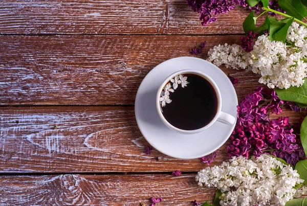 Copa de café y coloridas flores de lila en la mesa de madera del jardín —  Fotos de Stock