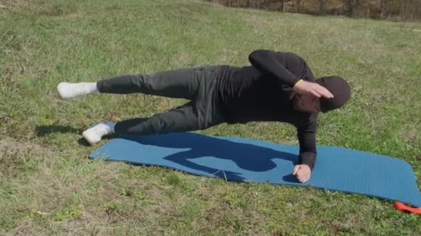 Playful Sportsman Extends Leg Him Fitness Mat Park — Stock Video