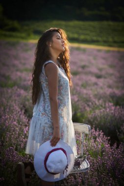 Lavanta tarlasında şapkası olan güzel esmer kızın portresi..
