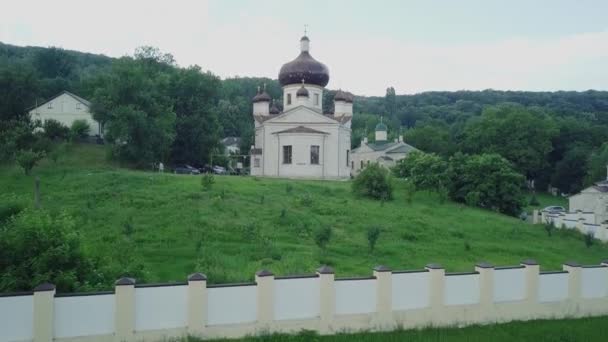 Ormanla çevrili bir Hıristiyan manastırının üzerinden uçmak. Condritsa Manastırı, Moldova Cumhuriyeti. — Stok video