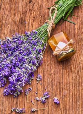 Lavanta yağı, tahta üzerinde bir demet lavanta çiçeği.