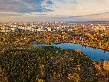 Sonbahar ağaçlarıyla dolu bir parktaki göl manzarası. Kishinev, Moldova. Suyun üzerinde destansı bir uçuş. Gündüzleri renkli sonbahar ağaçları.