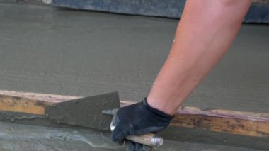 Uzun bir seviyelendirme aracı ile taze beton seviyelendiriliyor