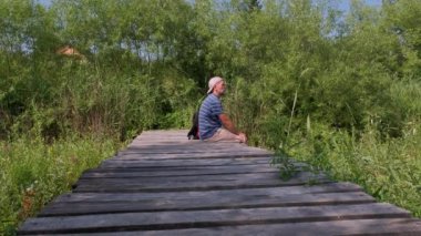 Yaşam için rahatlatıcı, doğal terapi konsepti. Yetişkin insanlar rahat bir şekilde oturur su yüzeyinde sallanır ağaçların kenarında güzel bir yaz günü, doğa nehri gölünde..