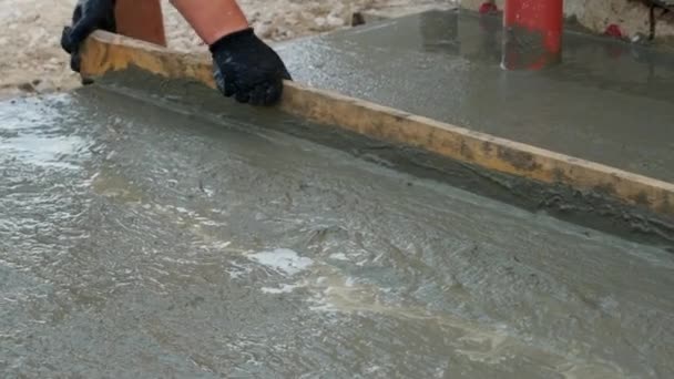 Nivelando o concreto fresco com uma ferramenta de nivelamento longo — Vídeo de Stock