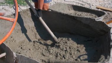 Çimentoyu karıştıran işçi. İnşaat havanı yapılıyor