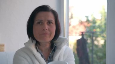 Mutlu kadın evde bir fincan sıcak çay ya da kahveyle dinleniyor.